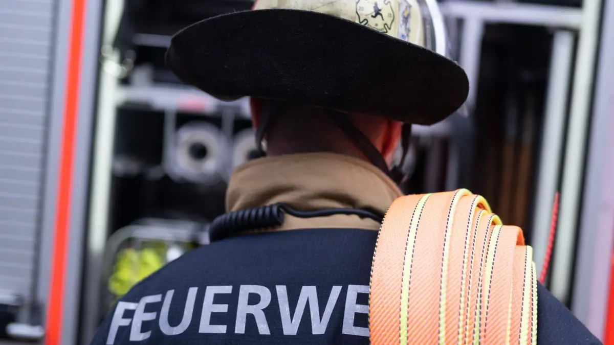 Feuerwehr: ARCHIV - 12.02.2025, Baden-Württemberg, Stuttgart: Eine Einsatzkraft der Feuerwehr steht im Hof der Feuerwache 5 Filder vor einem Einsatzfahrzeug (gestellte Szene). (zu dpa: «Bewohner nach Brandstiftung in Haft») Foto: Marijan Murat/dpa +++ dpa-Bildfunk +++