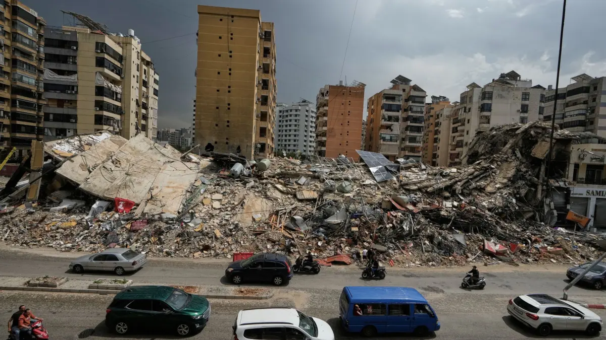 Iran-Krieg - Libanon: 17.04.2026, Libanon, Beirut: Anwohner fahren an den Trümmern zerstörter Gebäude in Dahija, einem südlichen Vorort von Beirut, Libanon, vorbei. Nach wochenlangen Kämpfen zwischen Israel und der libanesischen Hisbollah-Miliz ist eine Waffenruhe offiziell in Kraft getreten. Foto: Bilal Hussein/AP/dpa +++ dpa-Bildfunk +++