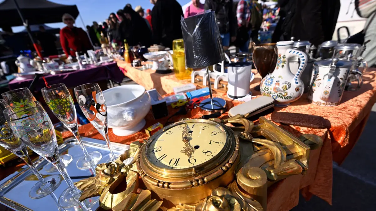 Münchner Frühlingsfest mit großem Flohmarkt: 18.04.2026, Bayern, München: Eine alte Uhr wird beim Flohmarkt des Deutschen Roten Kreuzes (DRK) auf der Theresienwiese angeboten. Foto: Felix Hörhager/dpa +++ dpa-Bildfunk +++