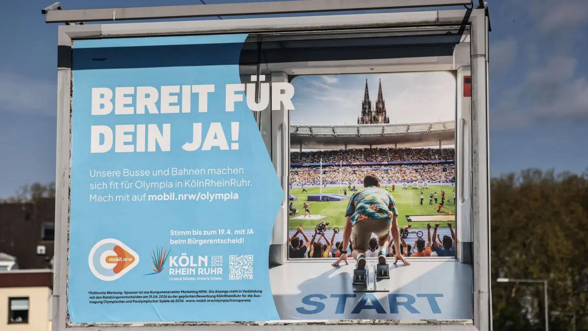 Werbeplakate Olympia-Volksentscheid: PRODUKTION - 17.04.2026, Nordrhein-Westfalen, Köln: Ein Werbeplakate zum Volksentscheid für eine Olympia-Bewerbung steht am Strassenrand. Foto: Oliver Berg/dpa - ACHTUNG: Nur zur redaktionellen Verwendung im Zusammenhang mit der aktuellen Berichterstattung +++ dpa-Bildfunk +++