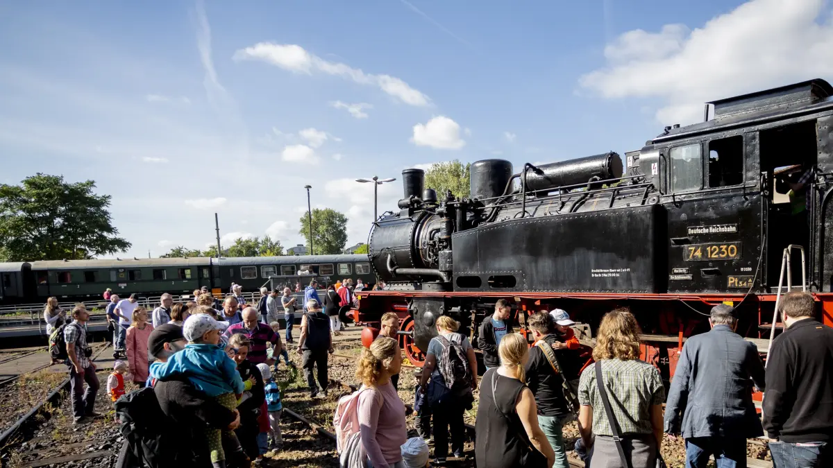 15.09.2018, Berlin: Besucher schauen sich beim 15. Berliner Eisenbahnfest im Bahnbetriebswerk Schöneweide eine Dampflokomotive der Baureihe 74 von 1916 an. Die von Borsig hergestellte Lokomotive fuhr als S-Bahn in Berlin und verwendete eine besondere Kohle, die weniger qualmt. Dampfzüge stehen im Mittelpunkt der zweitägigen Veranstaltung. Der Verein Dampflokfreunde Berlin präsentiert mehr als 20 Lokomotiven und Wagen. Foto: Christoph Soeder/dpa +++ dpa-Bildfunk +++