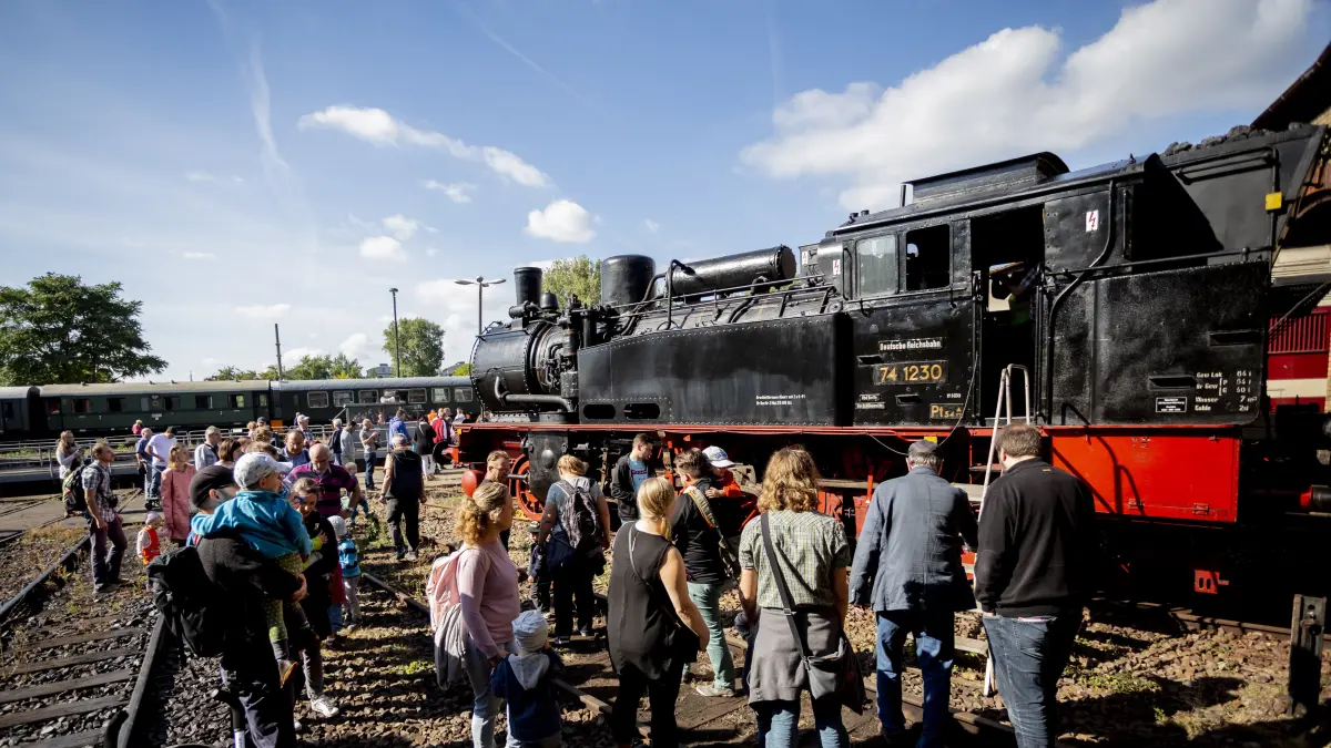 15.09.2018, Berlin: Besucher schauen sich beim 15. Berliner Eisenbahnfest im Bahnbetriebswerk Schöneweide eine Dampflokomotive der Baureihe 74 von 1916 an. Die von Borsig hergestellte Lokomotive fuhr als S-Bahn in Berlin und verwendete eine besondere Kohle, die weniger qualmt. Dampfzüge stehen im Mittelpunkt der zweitägigen Veranstaltung. Der Verein Dampflokfreunde Berlin präsentiert mehr als 20 Lokomotiven und Wagen. Foto: Christoph Soeder/dpa +++ dpa-Bildfunk +++