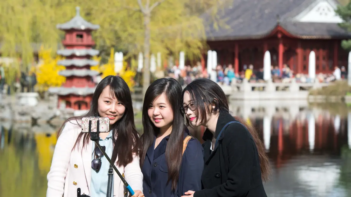 Drei junge Berlinerinnen fotografieren sich mit Hilfe einer Selfie-Stange am 12.04.2015 beim 9. Kirschblütenfest Hanami in den "Gärten der Welt" im Bezirk Marzahn-Hellersdorf in Berlin. Foto: Bernd von Jutrczenka/dpa ++ +++ dpa-Bildfunk +++