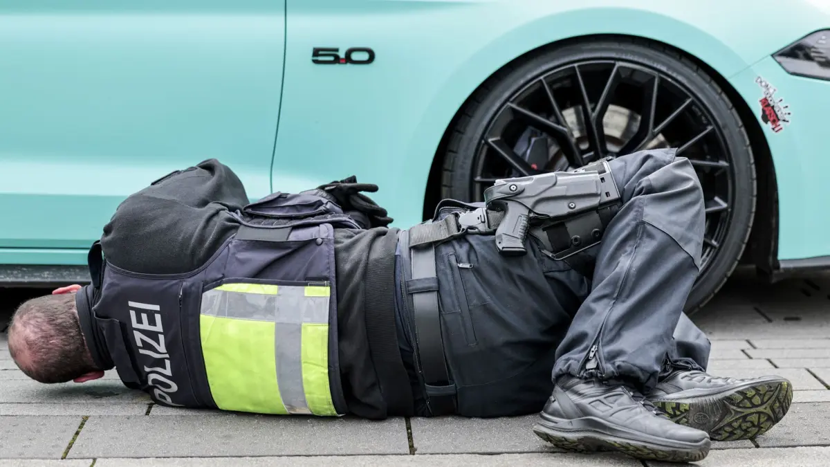 18.04.2025, Nordrhein-Westfalen, Düsseldorf: Polizeibeamte überprüfen am «Car-Freitag» ein Fahrzeug auf dem Corneliusplatz. Foto: Thomas Banneyer/dpa +++ dpa-Bildfunk +++