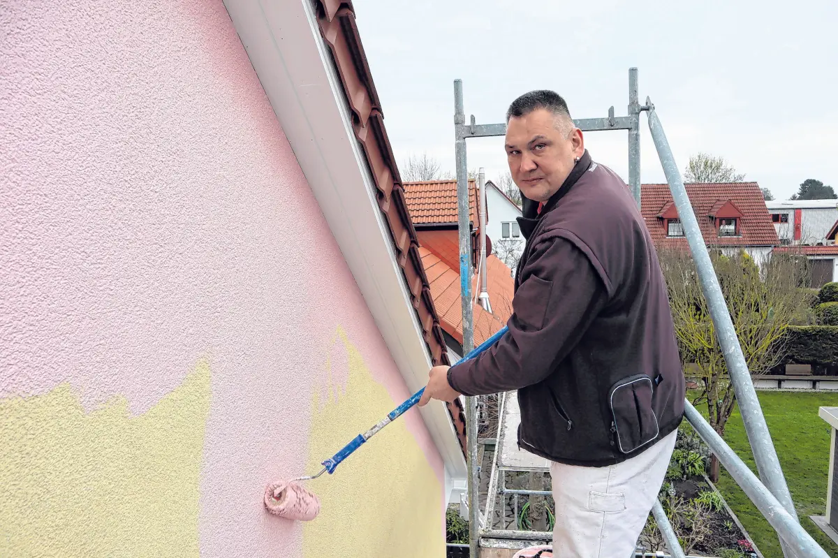 Handwerker Björn Feldner erfüllt die Wünsche einer Kundin in Müllrose und streicht das einst gelbe Haus rosa. ⇥Fotos: Anna Pröschild