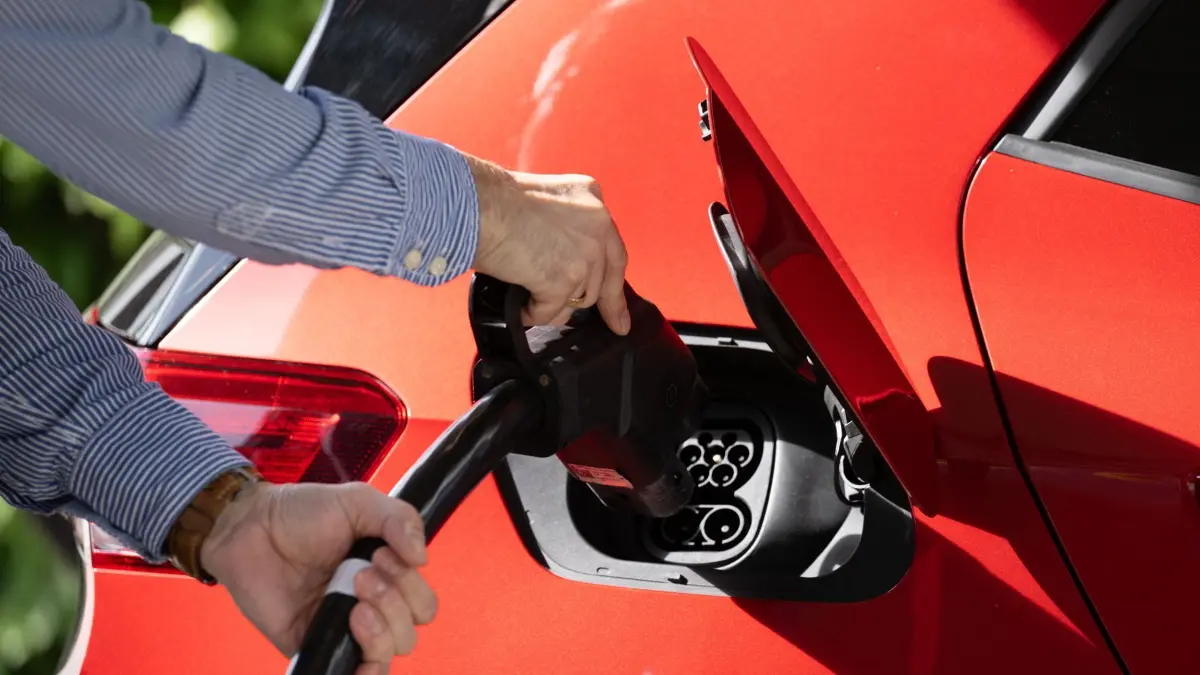 Ein Mann steckt im Rahmen eines Presserundgangs in einem Ladepark für Elektroautos vor der Gläsernen Manufaktur von Volkswagen ein Ladekabel in den Tankstutzen eines VW ID.3. (zu dpa: «E-Auto-Käufer vertrauen deutschen Marken - auch im Ausland») +++ dpa-Bildfunk +++