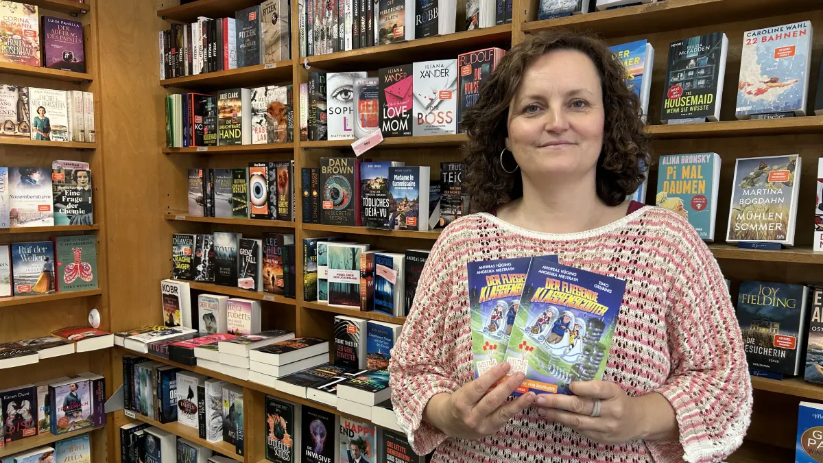 Im Schaufenster der Buchhandlung Papierblüte in Bad Freienwalde liegen Dutzende Ausgaben des Comics „Der fliegende Klassenscooter“. Inhaberin Sarén Jürgens erklärt, was das mit einer Schatzsuche in der Buchhandlung zu tun hat.