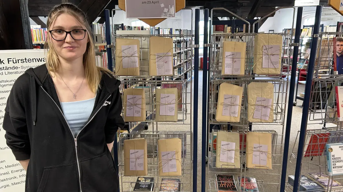 Praktikantin Jasmin Hübner neben den Blind-Dates-Büchern