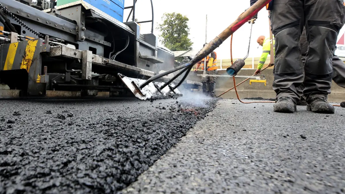 Preisexplosion bei Diesel und Bitumen: ARCHIV - 02.10.2020, Nordrhein-Westfalen, Mülheim: Arbeiter tragen auf einer Autobahn eine neue Asphaltdecke auf. (zu dpa: «Bitumen-Preis verdoppelt: Iran-Krieg verteuert Straßenbau») Foto: Roland Weihrauch/dpa +++ dpa-Bildfunk +++