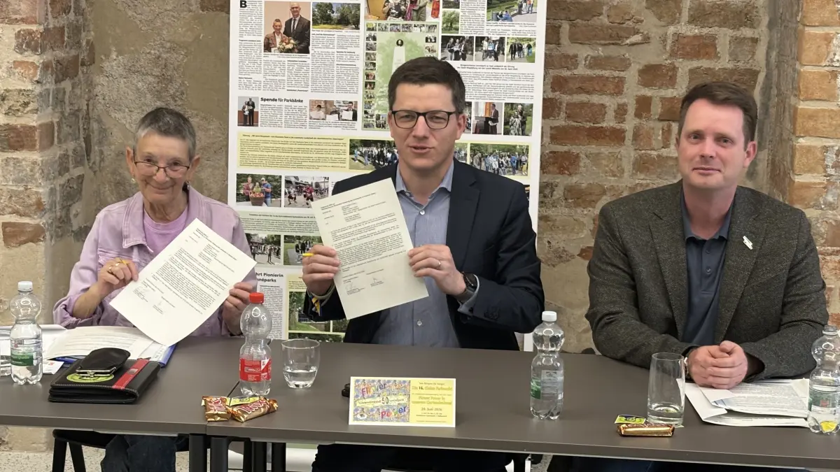 Sonja Gudlowski von der Bürgerinitiative, Bürgermeister Claus Junghanns und Florian Beck, Leiter des Tiefbauamtes (v. l. n. r..), bei der Unterzeichnung der jährlichen Kooperationsvereinbarung für den Lennépark in Frankfurt (Oder).
