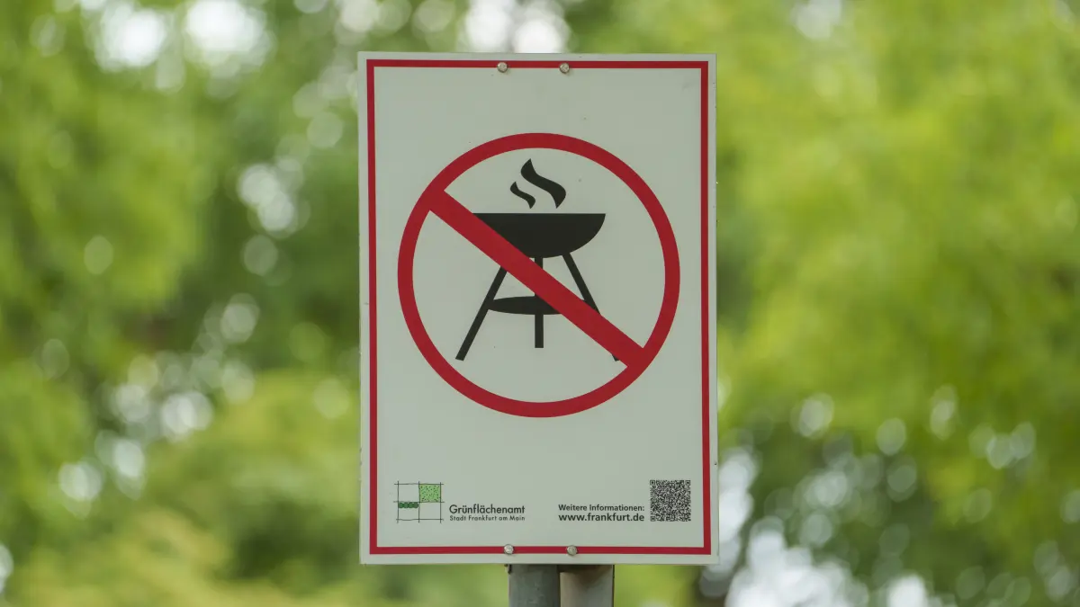 Ein Schild auf dem Lohrberg weist mit einem Piktogramm auf das Grillverbot hin. Am Mittwoch, dem 9. Juli, tritt in Frankfurt ein umfassendes Grillverbot in städtischen Grünanlagen in Kraft. Die Entscheidung des Umweltdezernats erfolgt auf Grundlage der anhaltend trockenen Witterungsverhältnisse – trotz gelegentlicher Regenschauer bleibt die Lage angespannt. +++ dpa-Bildfunk +++