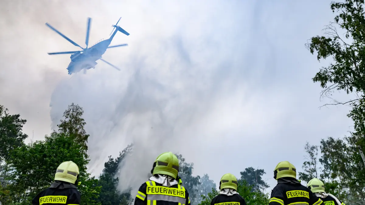 Ein Löschhubschrauber der Bundeswehr und Kräfte der Feuerwehr sind beim Waldbrand in der Gohrischheide im Einsatz. Das Waldgebiet zwischen Sachsen und Brandenburg brennt seit mehreren Tagen. +++ dpa-Bildfunk +++