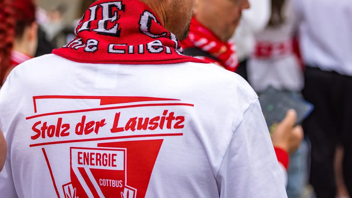 Energie Cottbus - SV Wehen Wiesbaden: 09.05.2026, Brandenburg, Cottbus: Fußball, Männer: 3. Liga, Energie Cottbus - SV Wehen Wiesbaden, 37. Spieltag, LEAG Energie Stadion. «Stolz der Lausitz» steht auf dem Trikot eines Fans von Energie Cottbus vor dem Spiel. Foto: Frank Hammerschmidt/dpa +++ dpa-Bildfunk +++