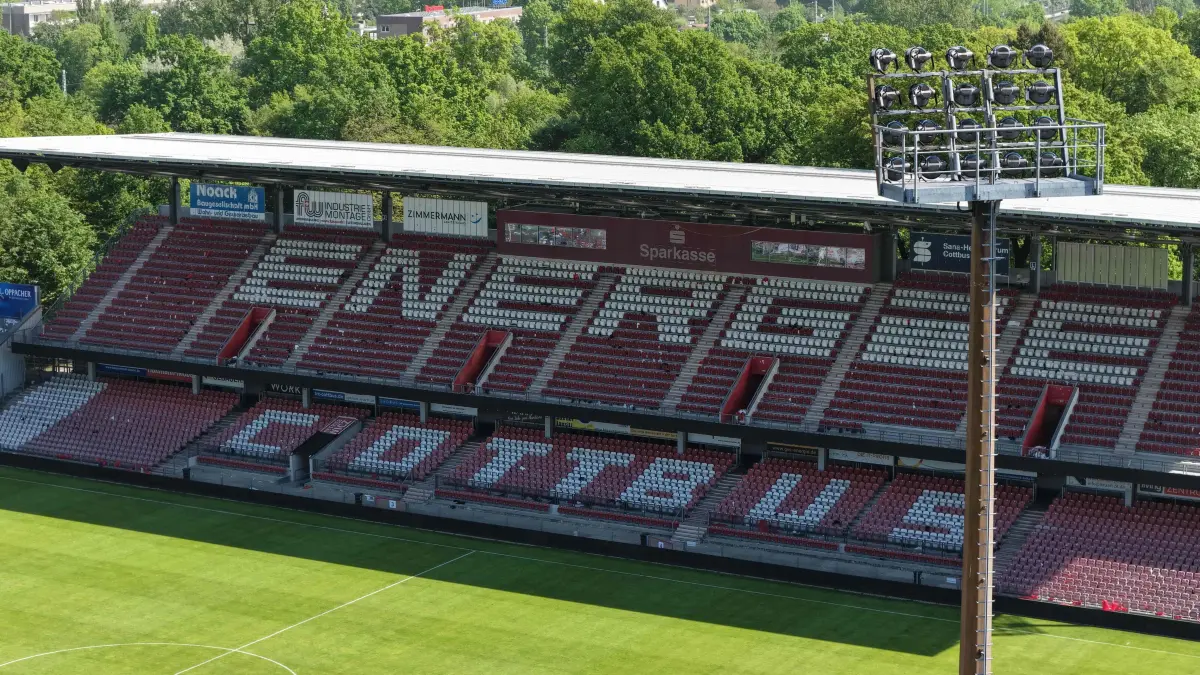 Luft FCE Leag Stadion: Luftaufnahme vom 10. Mai 2026
Blick auf das Leag Energie Stadion der Freundschaft
Brandenburgs Sportminister Gordon Hoffmann hat am Sonnabend, 9. Mai 2026, dem FC Energie Cottbus die Landesförderung zur Modernisierung des LEAG Energie Stadions überbracht.
Mit dem Zuwendungsbescheid erhält der FC Energie Cottbus eine Förderung über 1,67 Millionen Euro und damit den größten Teil der zugesicherten zwei Millionen Euro Landesförderung. Mit dem weiterhin noch zur Verfügung stehenden Restbetrag kann der Verein flexibel auf weitere Modernisierungserfordernisse reagieren, die erst im Zuge des Lizenzierungsverfahren für die 2. Bundesliga deutlich werden sollten. Im Vordergrund der Förderung stehen die Modernisierungen der Flutlichtanlage, der Infrastruktur für die mediale Übertragung, Verbesserungen im Besucherbereich sowie der Umbau einer Sporthalle für den Trainingsbetrieb. Die Gesamtinvestitionskosten belaufen sich auf knapp 2,1 Millionen Euro.