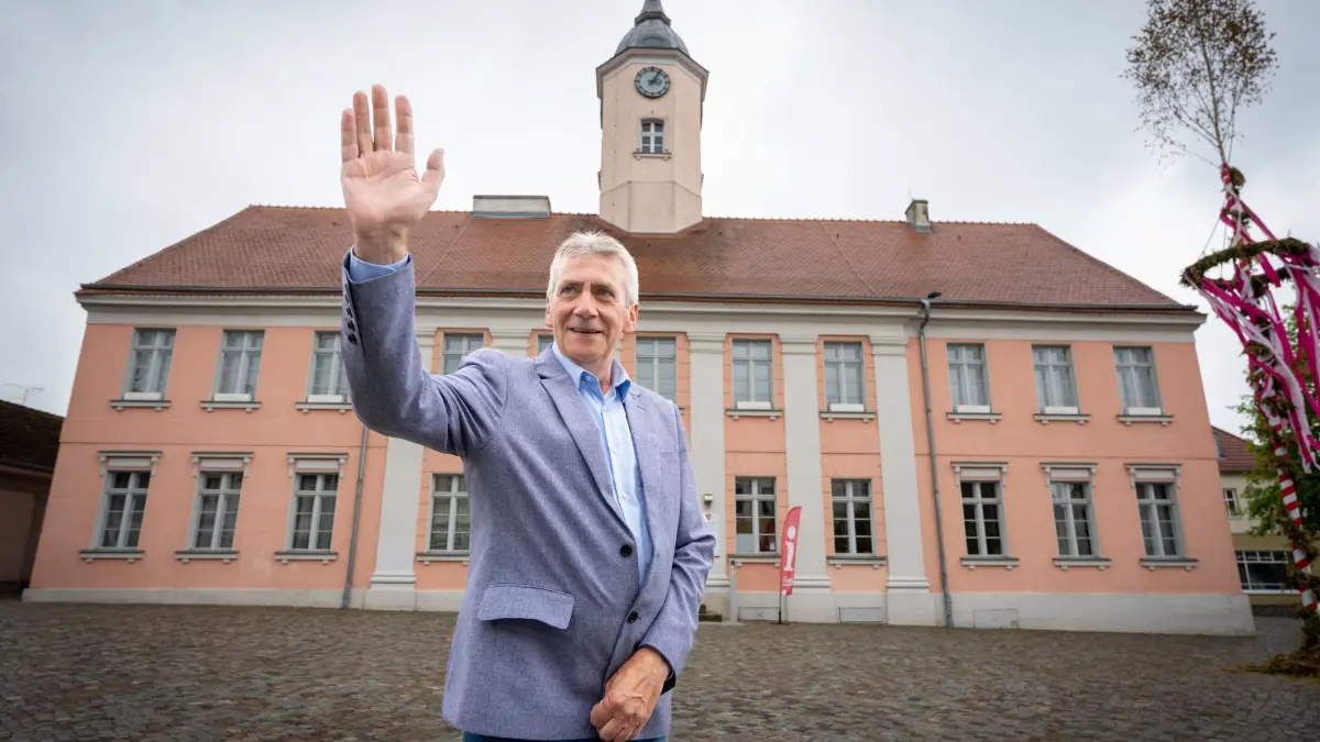 AfD-Kandidat gewinnt Bürgermeisterwahl in Zehdenick: 11.05.2026, Brandenburg, Zehdenick: Rene Stadtkewitz, Spitzenkandidat der AfD für die Bürgermeisterwahl, winkt während eines Fototermins vor dem Rathaus am Markt einem Mann zu, der ihn aus einem vorbeifahrenden Auto begrüßt hat. Stadtkewitz hat die Wahl zum Bürgermeister mit mehr als 50 Prozent der Stimmen gewonnen. Foto: Soeren Stache/dpa +++ dpa-Bildfunk +++