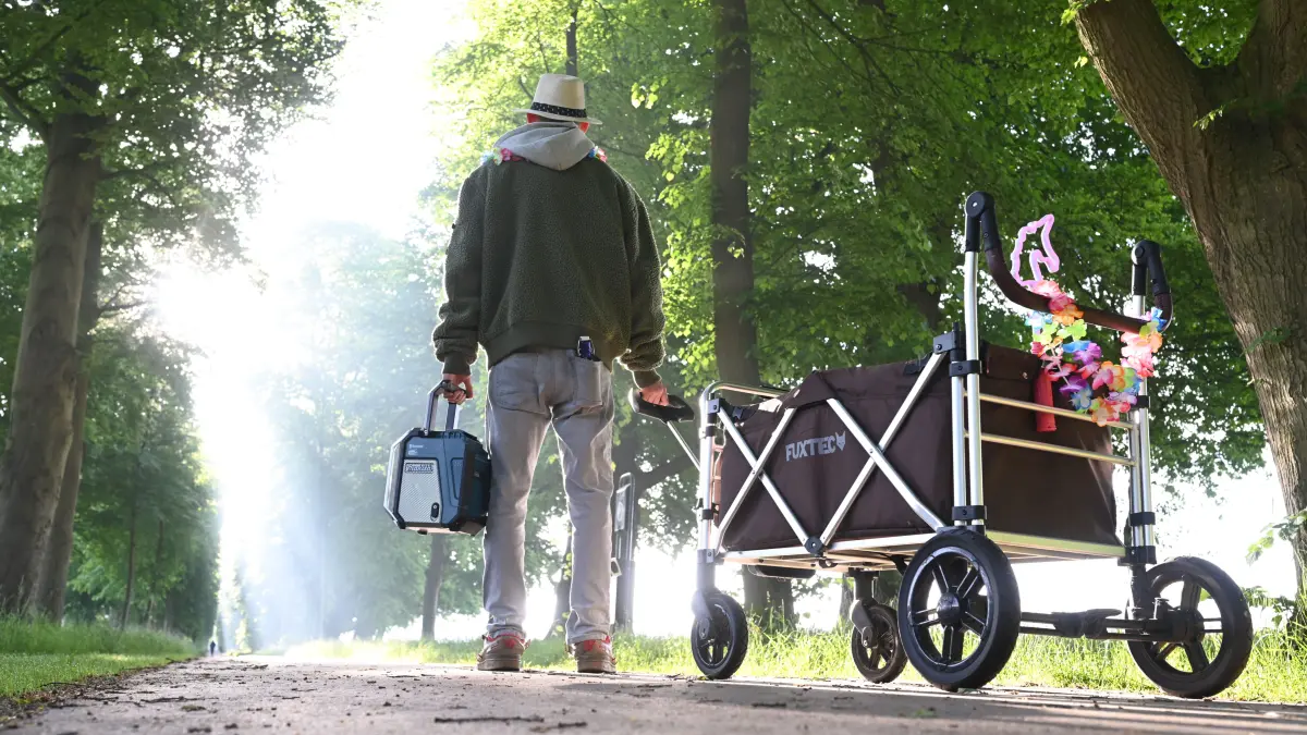 Ein junger Mann zieht bei bestem Wetter am frühen Morgen mit dem Bollerwagen los zum Treffpunkt einer Vatertagstour. +++ dpa-Bildfunk +++