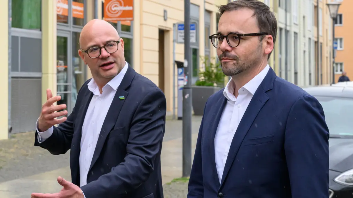 Start des deutsch-polnischen Polizeiteams: 13.05.2026, Brandenburg, Frankfurt (Oder): Axel Strasser (l, parteilos), Oberbürgermeister der Stadt Frankfurt (Oder) und Jan Redmann (CDU), stellvertretender Ministerpräsident und Minister des Innern und für Kommunales des Landes Brandenburg, gehen zum Termin Start des gemeinsamen Polizeiteams für Frankfurt (Oder) und der polnischen Nachbarstadt Slubice. Das deutsch-polnische Polizeiteam besteht aus einer grenzüberschreitenden Doppelstreife und umfasst insgesamt jeweils drei Bedienstete von deutscher und polnischer Seite. Das Team wird künftig mit einem Funkstreifenwagen, mit E-Bikes oder zu Fuß auf beiden Seiten des Flusses Oder ihren Dienst verrichten und nutz Räumlichkeiten im Zentrum von Frankfurt (Oder). Foto: Patrick Pleul/dpa +++ dpa-Bildfunk +++