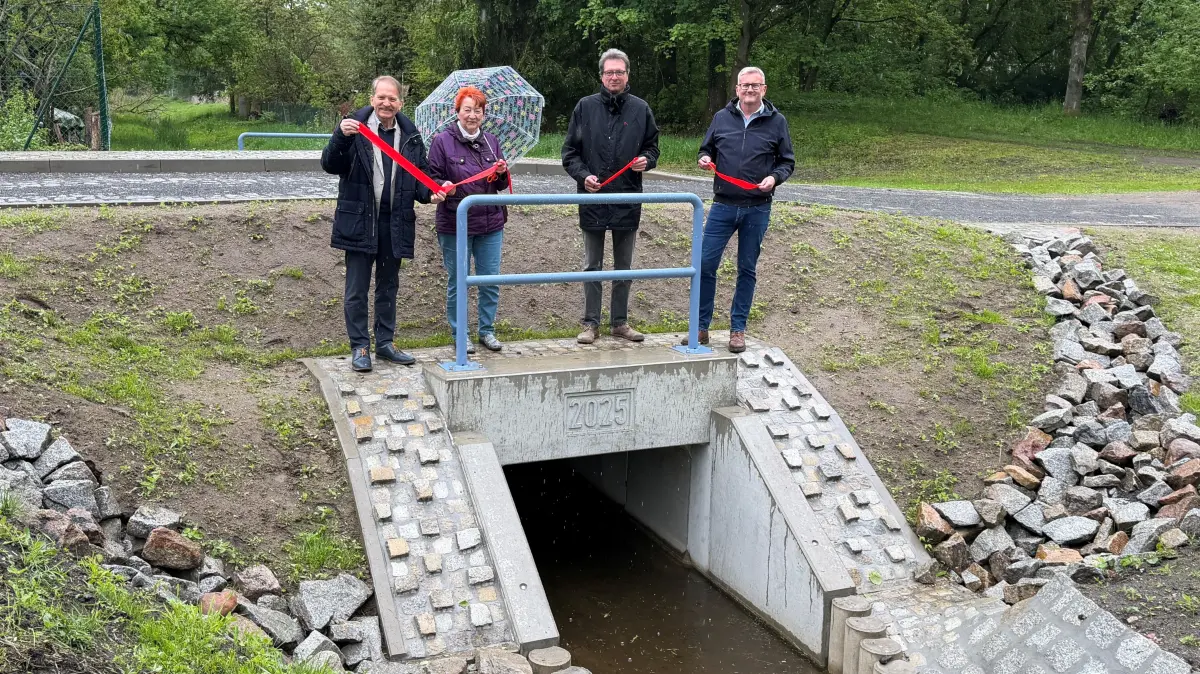 Bürgermeister Fritz-Georg Streichert, Ortsvorsteherin Monika Roth, Planer Lutz Schimke aus Frankfurt (Oder) und Heiko Sternberg (Geschäftsführer TSU) (v.l.) weihen den neuen Durchlass am Kleinbahnhof in Müncheberg ein. Obwohl vergleichsweise wenig Verkehr darüberläuft, war der Ersatz der baufälligen Brücke alternativlos.