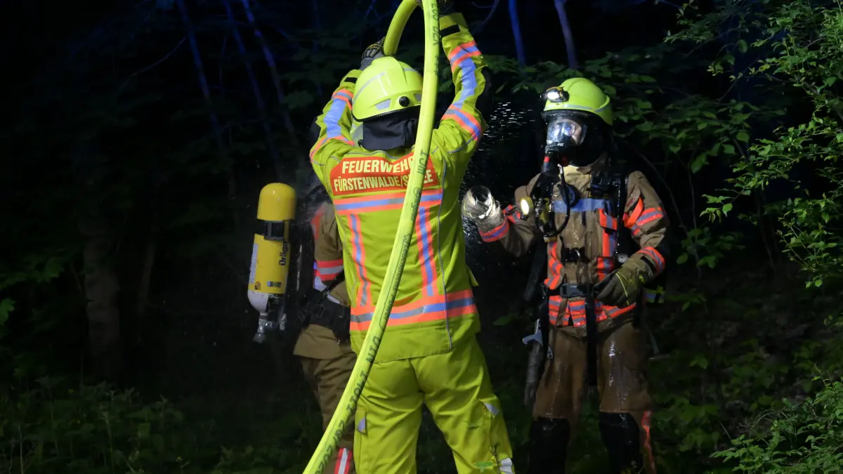 In der Frankfurter Straße in Fürstenwalde brannte am Freitagabend eine Hütte tief im Wald. Dichter schwarzer Rauch, ein schwieriger Zugang und offene Fragen zur Brandursache prägen den Einsatz.