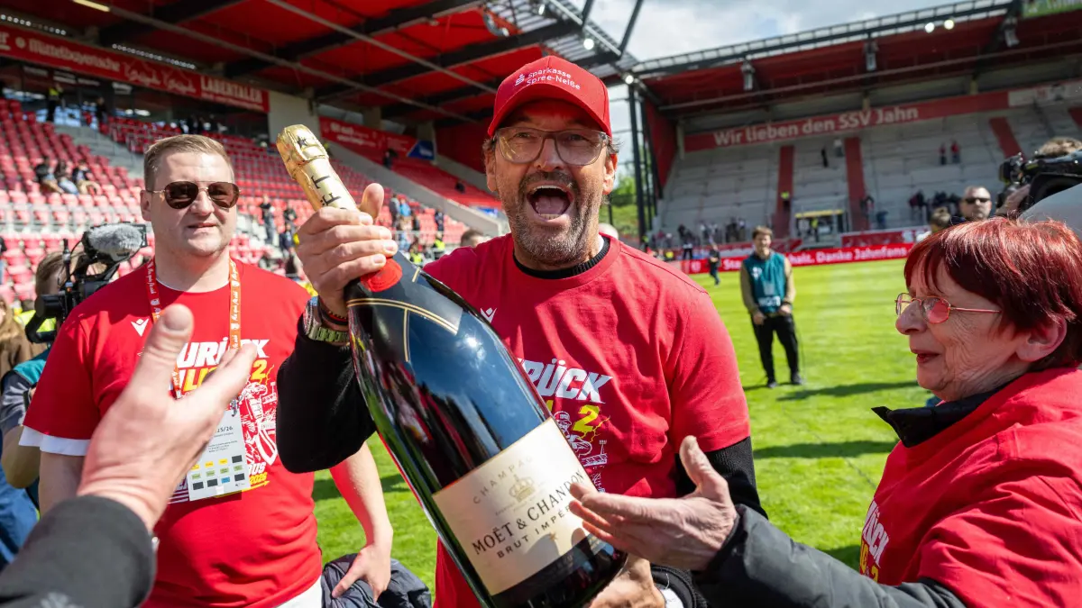 3. Liga Jahn Regensburg - Energie Cottbus 2025/26: Fussball, Herren, Saison 2025/2026, 3. Liga (38. Spieltag), SSV Jahn Regensburg - FC Energie Cottbus, Trainer Claus-Dieter Pele Wollitz (Energie Cottbus) nach Abpfiff mit Champagner, 16.05. 2026, Foto: Sebastian Räppold / Matthias Koch