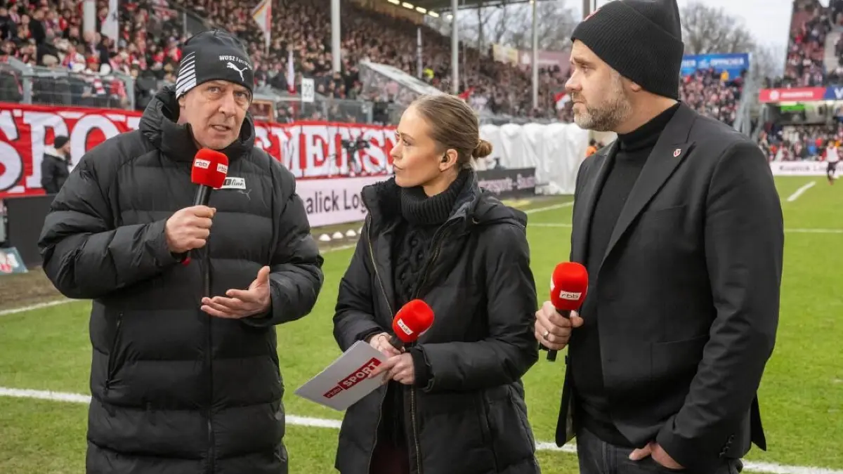 Will dem Fußballsport im Osten helfen: Mario Basler (links). Hier steht der Energie-Edelfan im Januar 2025 in Cottbus beim Ost-Derby gegen Dynamo Dresden in der Halbzeitpause Caroline Labes (Mitte) vom rbb und FCE-Präsident Sebastian Lemke Rede und Antwort.