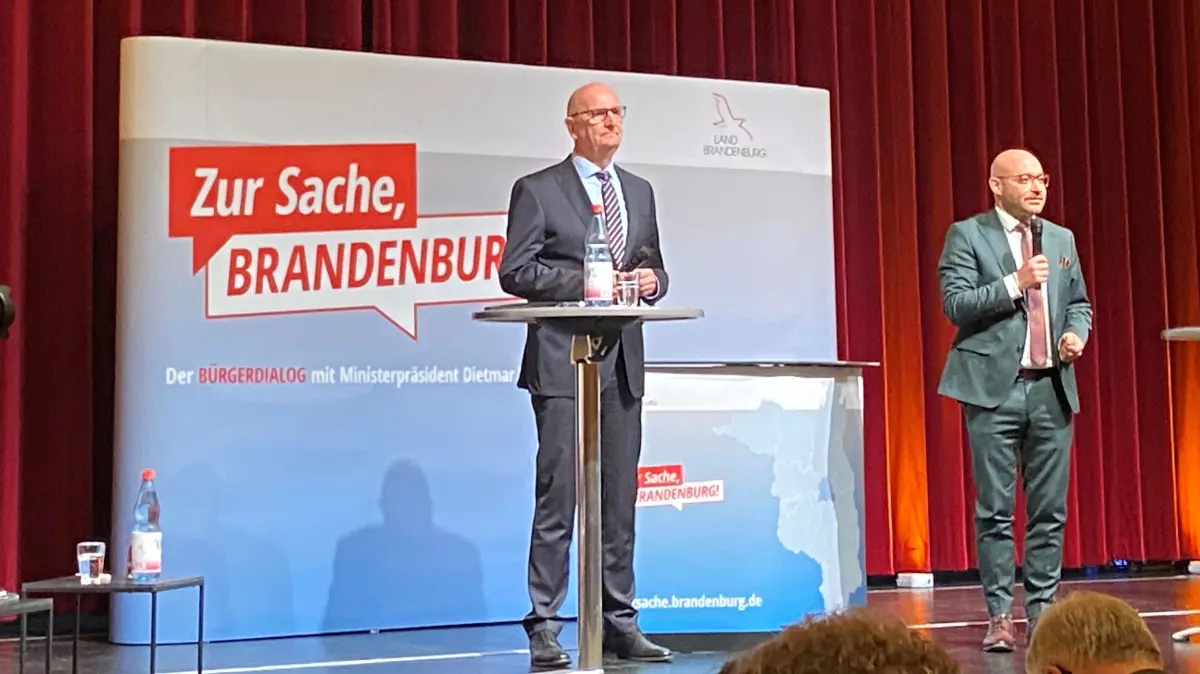 Ministerpräsident Dietmar Woidke und Sozialminister René Wilke (beide SPD) auf der Bühne im Kulturzentrum Rathenow beim Bürgerdialog "Zur Sache, Brandenburg!"