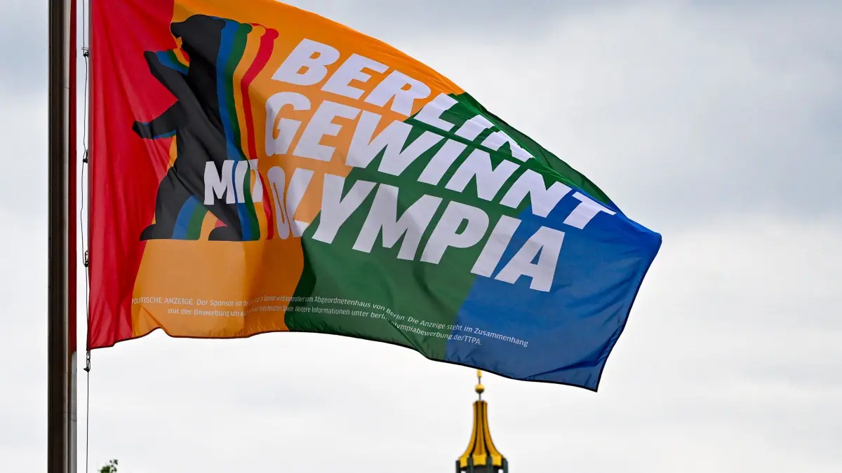 Olympia-Flagge weht vor dem Roten Rathaus: 22.05.2026, Berlin: Die Olympia-Fahne weht am Roten Rathaus, im Hintergrund der Dom. Foto: Jens Kalaene/dpa +++ dpa-Bildfunk +++
