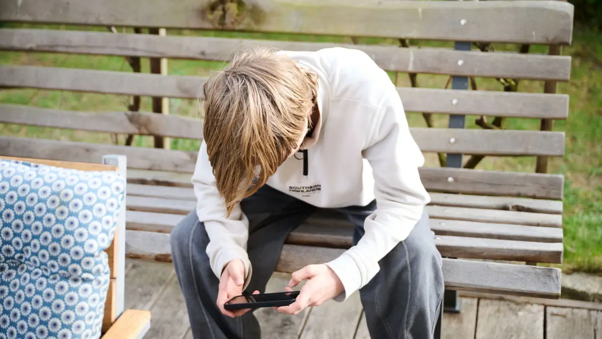 Ein Junge guckt auf sein Smartphone