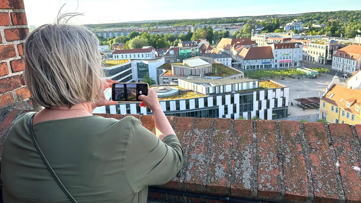 Blick auf Eberswalde: Eine Besucherin der Nacht der offenen Kirchen nutzt am frühen Abend die Gelegenheit, von der Turmplattform der Maria-Magdalenen-Kirche aus die halbe Innenstadt fotografieren zu können. Sie steht in 28 Meter Höhe.