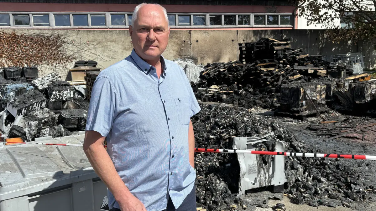 Bernd Stenzel, Geschäftsführer der Achse GmbH Kraftverkehr Frankfurt (Oder), steht vor den verbrannten Batterien auf seinem Betriebsgelände in der Goepelstraße. Noch darf er die Brandstelle nicht räumen.