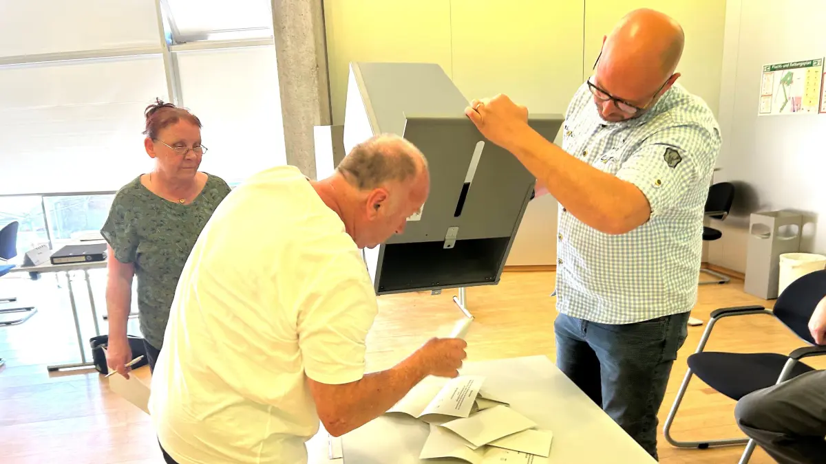 Die Wahlurne wird geleert: Im Hauptausschuss von Eberswalde beginnen Karen Oehler, Bündnis 90 Die Grünen, Florian Eberhardt, AfD, und Daniel Winkelmann, Bündnis Eberswalde, von links, die zusammen die Wahlkommission bilden, gleich mit dem Auszählen der Stimmen.