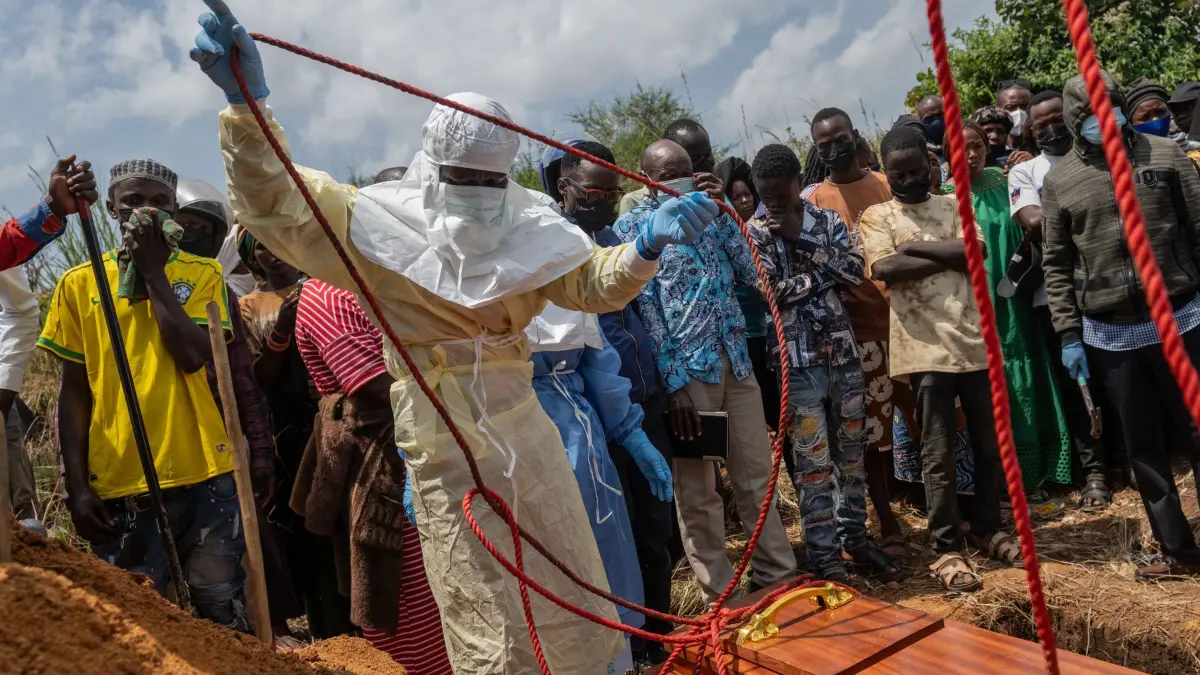 Ebola in der DR Kongo: ARCHIV - 23.05.2026, Demokratische Republik Kongo, Rwampara: Mitarbeiter des Roten Kreuzes bereiten einen Sarg mit dem Leichnam eines Ebola-Opfers für die Bestattung auf dem Rwampara-Friedhof in Rwampara vor. (zu dpa: «Angst, Verdrängung und Tradition erschweren Ebola-Bekämpfung») Foto: Moses Sawasawa/AP/dpa +++ dpa-Bildfunk +++