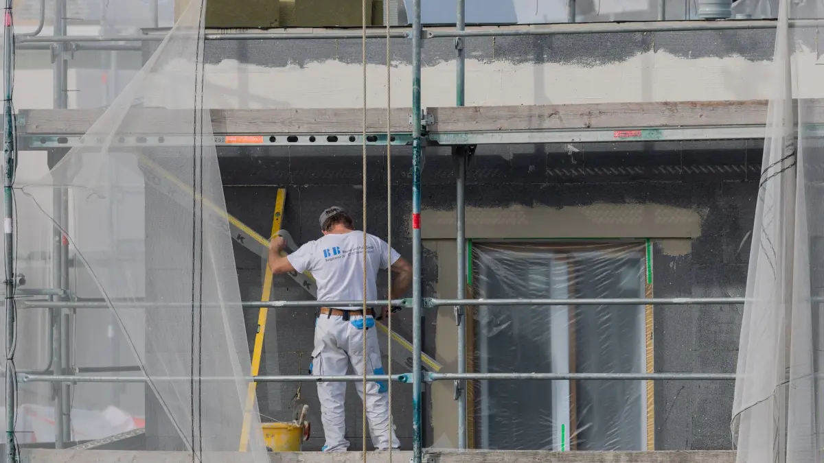 Wohnungsbau hat in Thüringen zuletzt länger gedauert: ARCHIV - 24.03.2026, Nordrhein-Westfalen, Köln: Bauarbeiter verputzen eine gedämmte Fassade auf einer Baustelle für frei finanzierte Eigentumswohnungen im KFW40 QNG Standard. (Symbolbild) (zu dpa: «Baugenehmigung bis Einzug - So lange dauert es in Thüringen») Foto: Rolf Vennenbernd/dpa +++ dpa-Bildfunk +++
