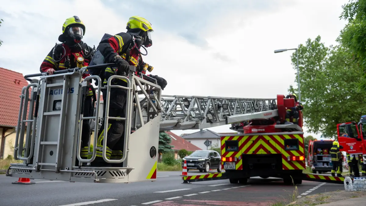 Mit einer Drehleiter öffnen die Feuerwehrleute Teile des Daches.