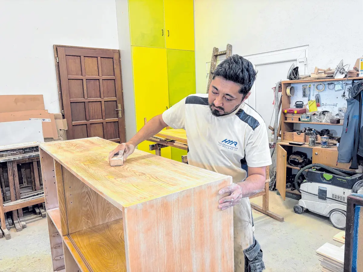 Beim Schleifen einer Regaloberfläche: Mitarbeiter Zakaria Rajabi. Seit vielen Jahren gehört er zum Team der Holzmanufaktur Roland.