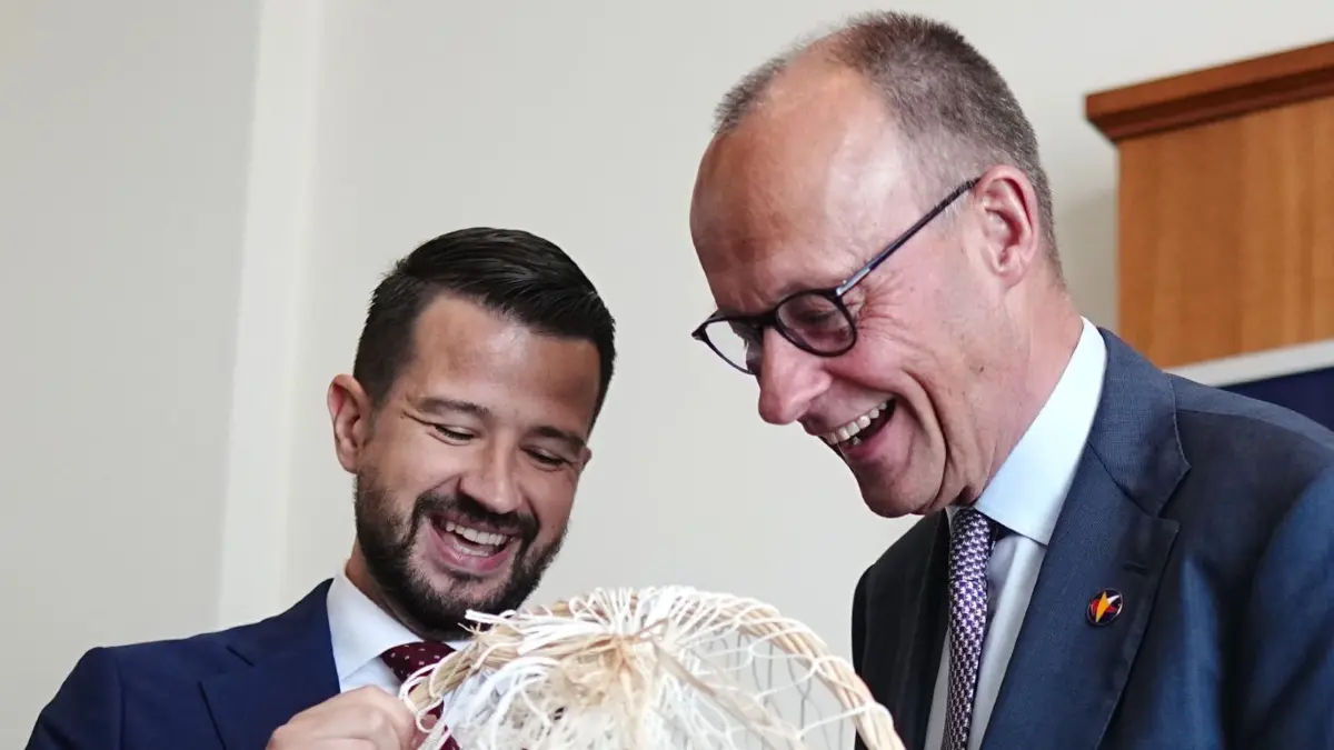 Bundeskanzler Merz reist zum EU-Westbalkan-Gipfel: 05.06.2026, Montenegro, Tivat: Bundeskanzler Friedrich Merz (CDU, r) und Jakov Milatovic, Präsident von Montenegro, tauschen beim EU-Westbalkan-Gipfel Gastgeschenke aus. Bei dem Spitzentreffen soll es auch um die EU-Beitrittsperspektive der Westbalkanländer Albanien, Bosnien-Herzegowina, Kosovo, Montenegro, Nordmazedonien und Serbien gehen. Eingeladen sind die Staats- und Regierungschefs der EU-Staaten und Westbalkanländer. Foto: Kay Nietfeld/dpa +++ dpa-Bildfunk +++