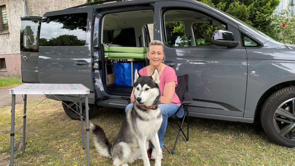 Jacqueline Urban und ihr Husky Kenji vor dem selbst ausgebauten Camper-PKW