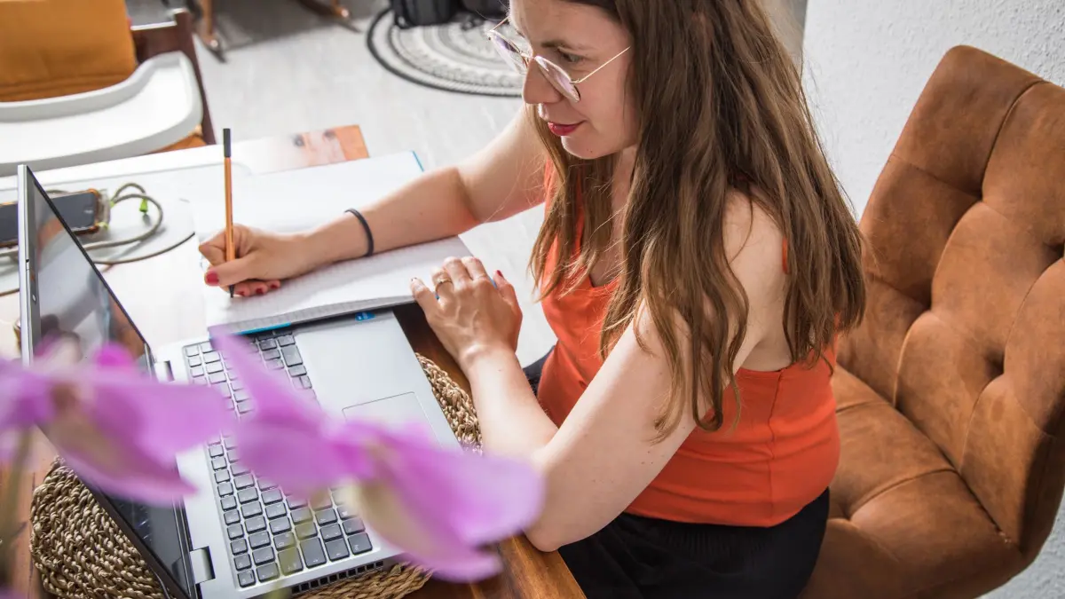 Eine Frau macht sich Notizen neben dem Laptop: ILLUSTRATION - Stift oder Tastatur? Wer im Gespräch stichpunktartig mitschreibt, merkt sich mehr – und kann danach schneller ein Protokoll oder To-dos ableiten. (zu dpa: «Mehr merken im Job: Tipps für effektive Gesprächsnotizen») Foto: Christin Klose/dpa-mag - Honorarfrei nur für Bezieher des Dienstes dpa-Magazin +++ dpa-Magazin +++