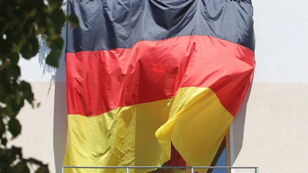 Eine Deutschlandflagge hängt von Balkon zu Balkon: ARCHIV - Deutschlandflagge bis zum Nachbarn? WM-Balkon-Deko ist erlaubt, solange sie niemanden verschattet oder gefährdet. (zu dpa: «Fußball-WM: Was Fans in Mietwohnungen beachten müssen») Foto: Jens Wolf/dpa-Zentralbild/dpa-tmn - Honorarfrei nur für Bezieher des dpa-Themendienstes +++ dpa-Themendienst +++