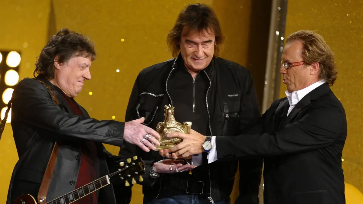 Wolfgang Lippert (r.) und Dieter Birr (Mitte) kennen sich seit Jahrzehnten, am 5. Juli plaudern beide in Bad Saarow bei „Leute bei Lippert“. 2009 durfte der Entertainer dem Ostrocker den Medienpreis Goldene Henne überreichen (hier zu sehen mit Dieter Hertrampf).