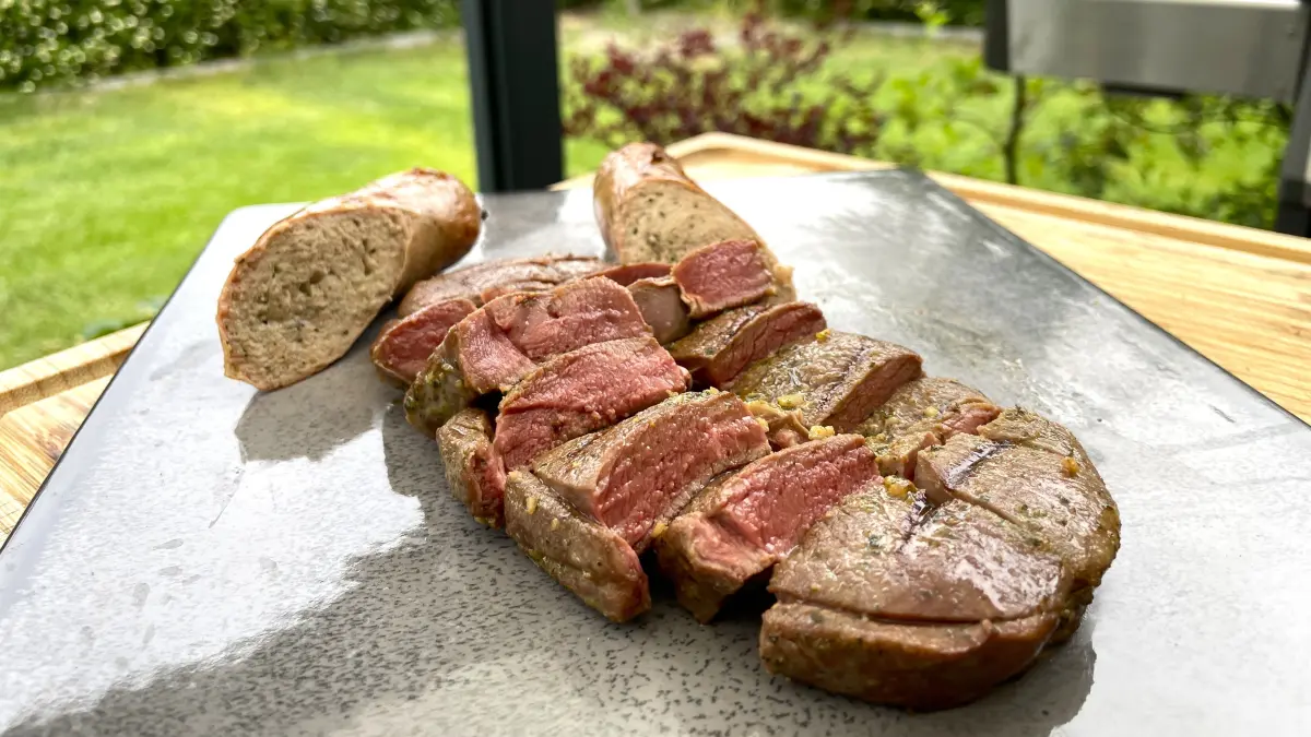 Rehsteak und Wildbratwurst von Wildkauf Schultka im Test: Wer die Hinweise zum Grillen beachtet, erhält zartes Fleisch in milder Marinade und eine kräftig gewürzte Wurst. (Foto vom 12.06.2026)
