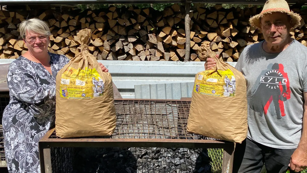 Sind derzeit knapp: die begehrten Zehn-Kilo-Säcke mit der Groß Lindower Holzkohle aus Buchenholz. Die Vorstandsmitglieder des produzierenden Kienstubbenvereins Kristin Fredeland und Ralf Raschke halten die letzte Holzkohle für das Köhlerfest am 3. Oktober 2026 fest.