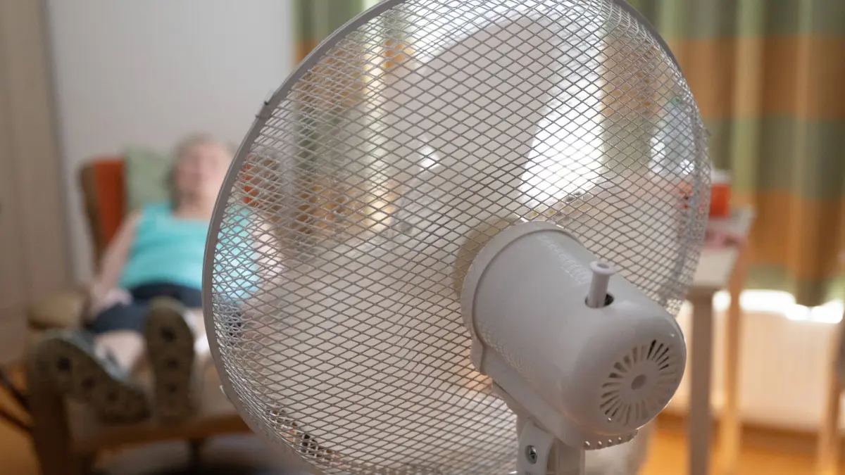 Hitze in Deutschland: ARCHIV - 02.07.2025, Sachsen, Dresden: Die Bewohnerin eines Seniorenzentrums sitzt in ihrem Zimmer hinter einem Ventilator in einem Sessel. (zu dpa: «Ministerin warnt vor Hitze – Senioren besonders gefährdet») Foto: Sebastian Kahnert/dpa +++ dpa-Bildfunk +++