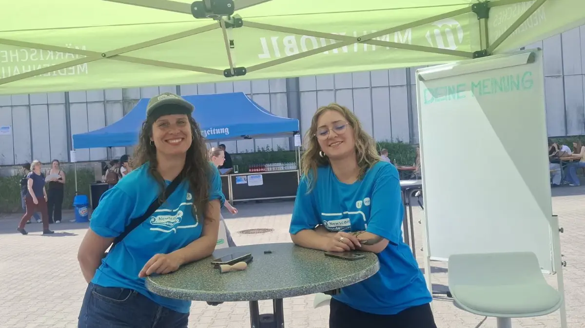 Nicole Buhlau (r.) und Victoria Schloder erklären den Teilnehmern des diesjährigen Newscamps in Frankfurt (Oder), was sie am Glücksrad gewinnen können.