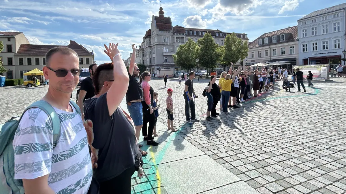 Hunderte Teilnehmer formten auf dem Schulplatz in Neuruppin die weltweit größte menschliche Birne. Eigentlich sollte der Weltrekordversuch damit eingestellt werden.