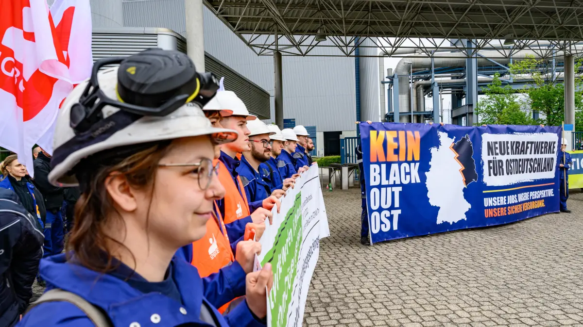 Auszubildende vom Energiekonzern Leag stehen mit einem Transparent mit der Aufschrift «Kein Blackout Ost - Neue Kraftwerke für Ostdeutschland» auf der Kundgebung «Milliarden für den Süden, leere Versprechen für den Osten» vor dem Braunkohlekraftwerk Schwarze Pumpe. Der Energiekonzern Leag sieht die Lausitz bei neuen Gaskraftwerken benachteiligt. Ein Gesetzentwurf sieht vor, dass rund zwei Drittel neuer Kraftwerkskapazitäten in ersten Ausschreibungsrunden in den sogenannten «netztechnischen Süden» gelenkt werden. +++ dpa-Bildfunk +++