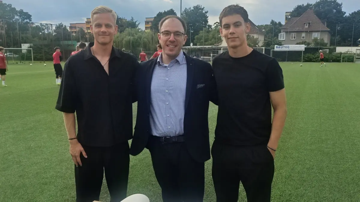 Janne Sietan (l.) und Frederik Schmahl (r.) posieren mit Sten Marquaß, dem Leiter der Lausitzer Sportschule.