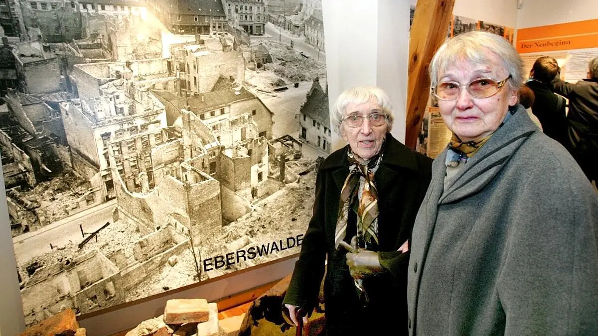 Zeitzeuginnen aus Eberswalde: Diese 2005 im Museum entstandene Aufnahme zeigt die Fotografinnen Ursula Mächler und Gertrud Krumnow vor einem Bild, das sie 1946 gefertigt haben. Das Ausmaß der Zerstörungen durch den Zweiten Weltkrieg wird darauf überdeutlich.