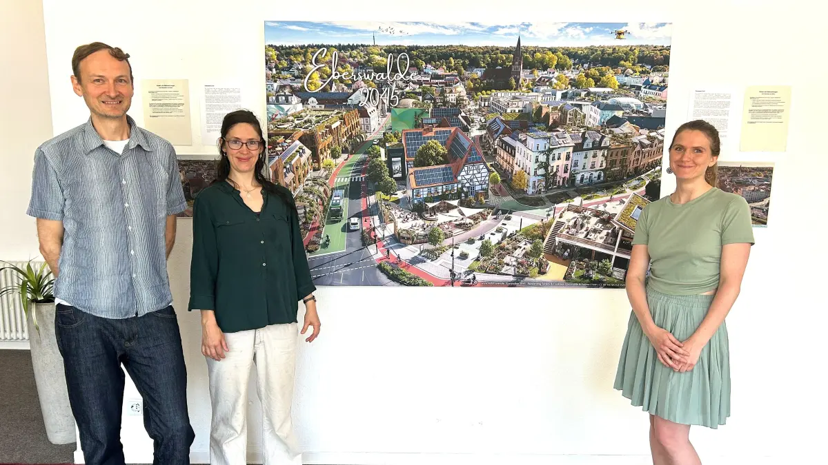 Zukunftsvision für Eberswalde: Ingo Frost, Sarah Holzgreve und Larissa Reise (v. l.) stehen in der Thinkfarm vor dem Bild im Format von 1,20 Meter mal 1,80 Meter, das die Kreisstadt des Barnims im Jahr 2045 zeigt.