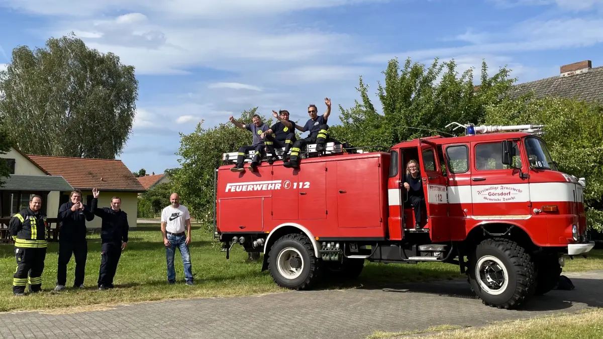 Der letzte in Oder-Spree im Einsatz befindliche Feuerwehr-W50, das Dorf und die Feuerwehrkameraden Christian Panzer, Robert und Florian Droldner, Ortsvorsteher Steffen Panzer, Frank und Harald Panzer, Nico Savaskan und, in der offenen Tür, Ramona Droldner aus Görsdorf laden ein zum Dorffest.